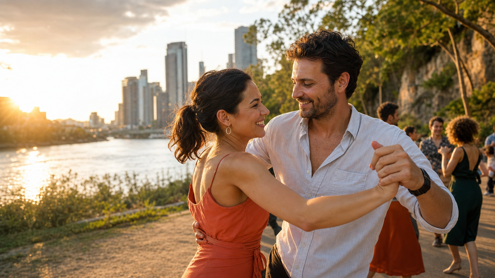 Two people smiling as they dance beside the Brisbane River